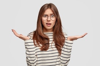 questioned indignant pleasant looking brunette woman with hands hesitant gesture wears striped casual sweater 1 Clases de alemán online