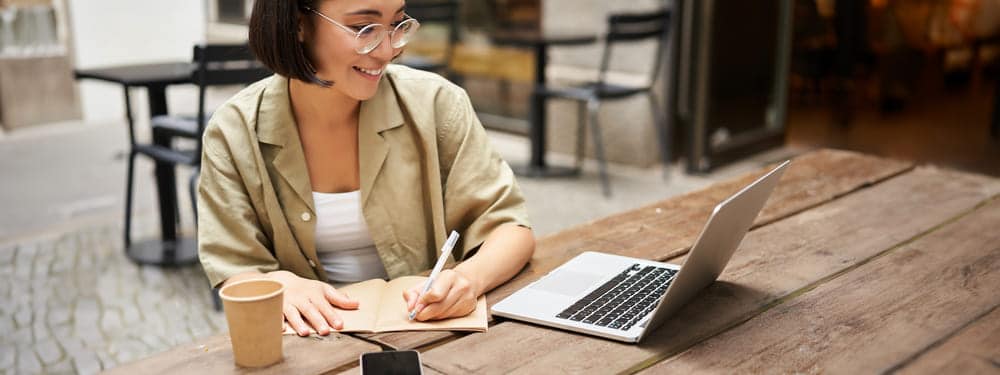 portrait concentrated girl doing homework attending online course making notes while working 1 1 Clases de alemán online